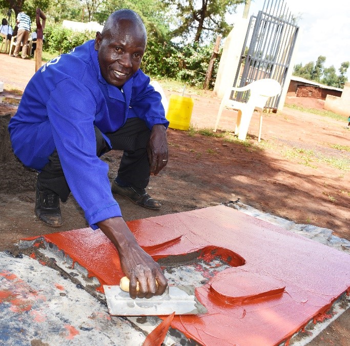 A photo of a man preparing a low cost sanitation solution