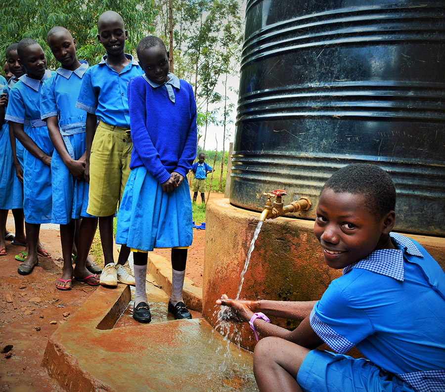 A photo of a student washing hands with others standing in line